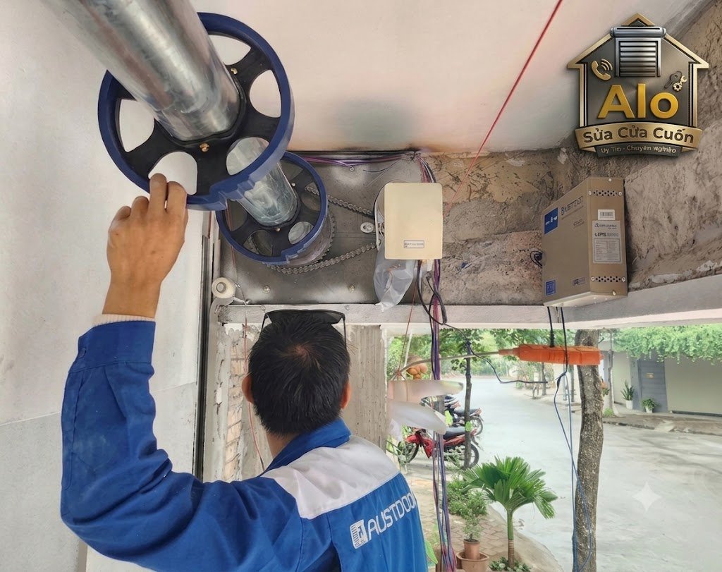 Thợ Alo Sửa Cửa Cuốn đang kiểm tra độ thẳng và gối đỡ của trục cửa cuốn
